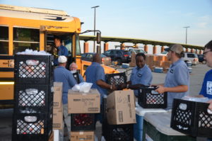 School feeding program workers load bus for neighborhood deliveries