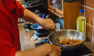 Person cooking with saute pan