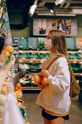 woman in mask shopping for fruit