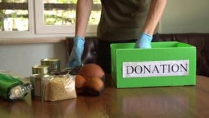 Individual packing a food donation box