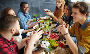 Group talking around a table sharing a meal