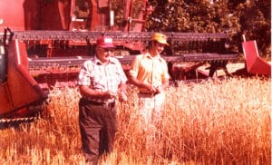 Harry and John Young standing in a field cultivated with no-till method