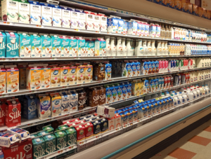 Dairy aisle in grocery store shows variety of milk products being sold
