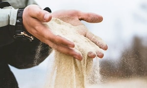 A man letting sand sift through his hands