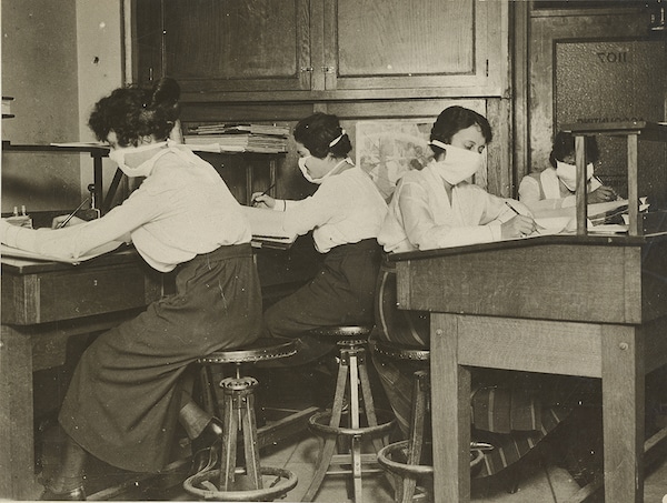 clerks with facemasks working during the Spanish Flu