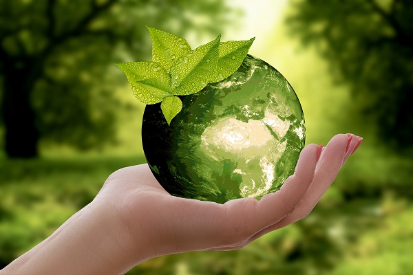 Green planet in a woman's hand